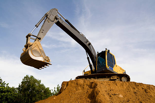 "Excavator at work,removing a large amount of earth from construction site."